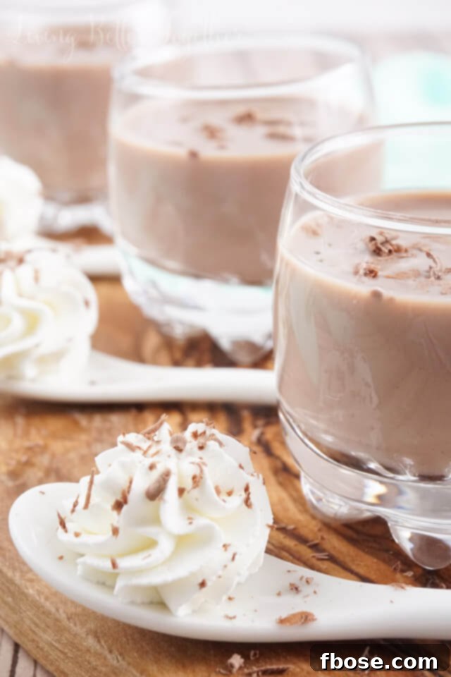 Close-up of a Chocolate Cream Pie Shot garnished with whipped cream and chocolate shavings