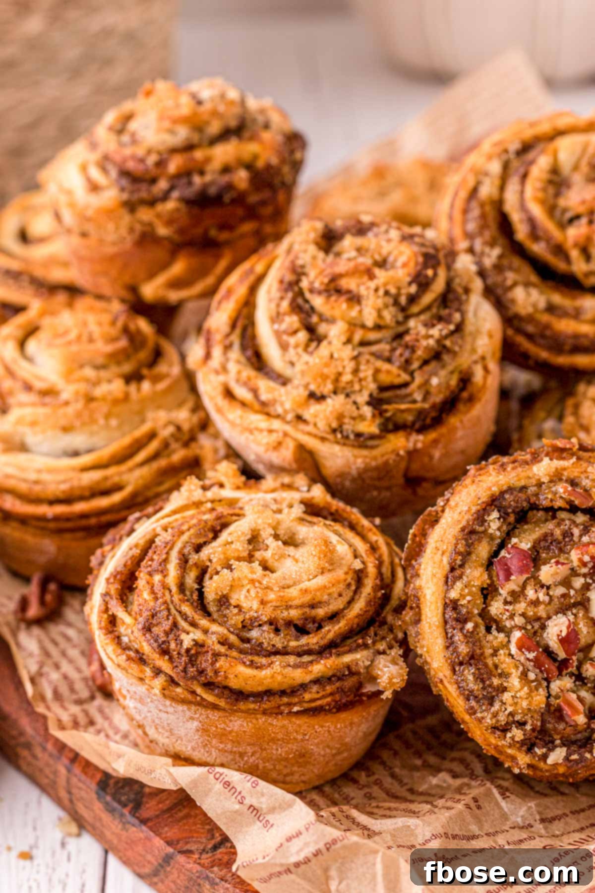 Pumpkin Cinnamon Roll Muffins piled on top of each other, ready to be served.