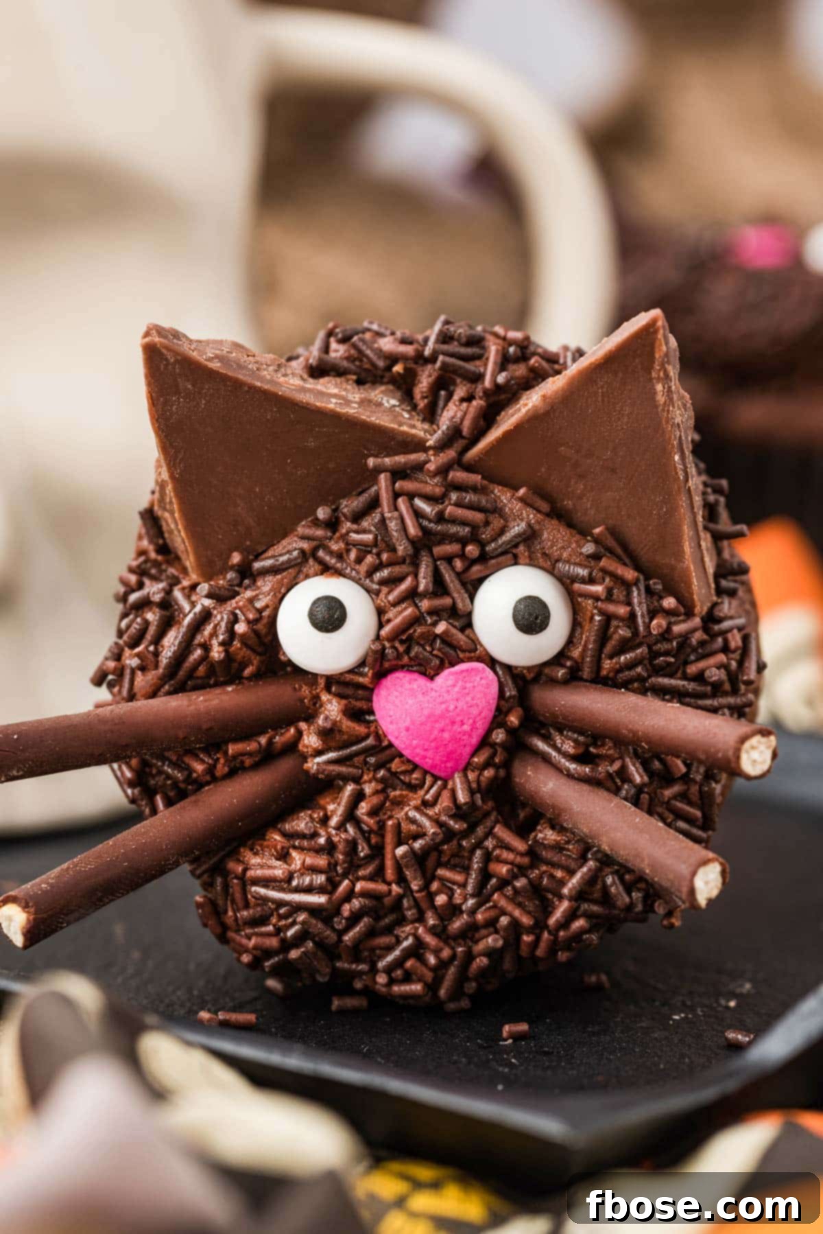 Black cake cupcake on it's side showing the face, whiskers, and ears.