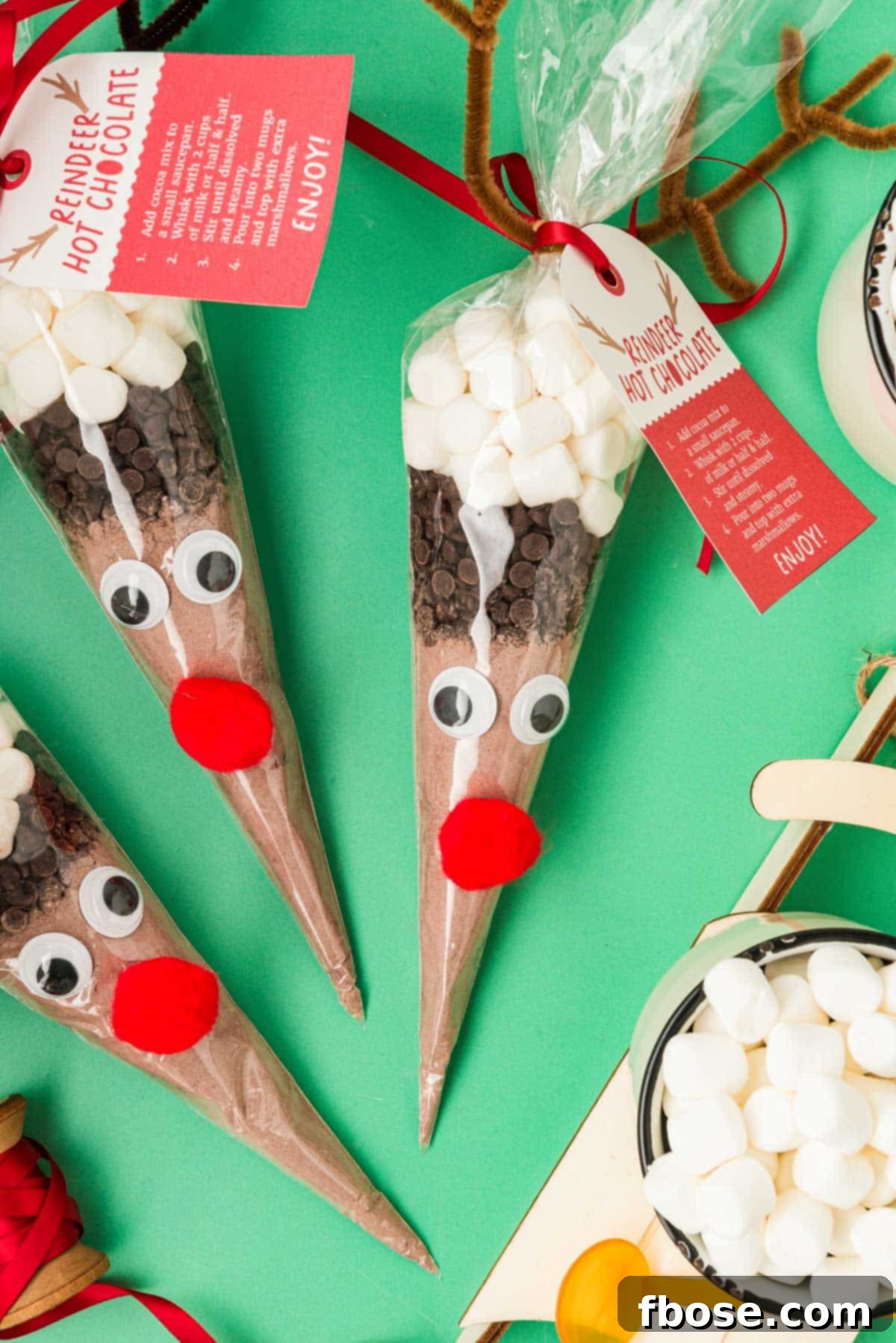 Reindeer hot chocolate cones on a green surface.