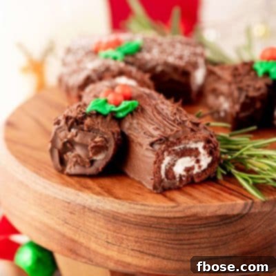 Mini yule log cakes on a wooden cake stand.