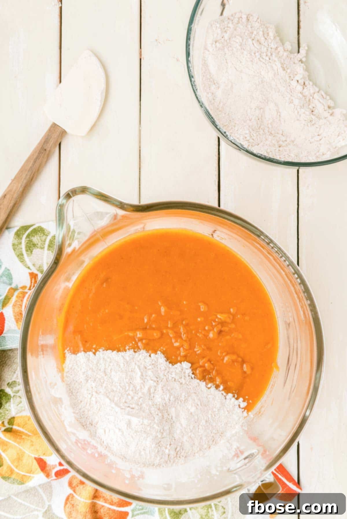 Effortless Autumn Pumpkin Bake 8 The pumpkin cake batter, now fully combined, is ready in a bowl, showcasing its smooth consistency and vibrant autumnal color.