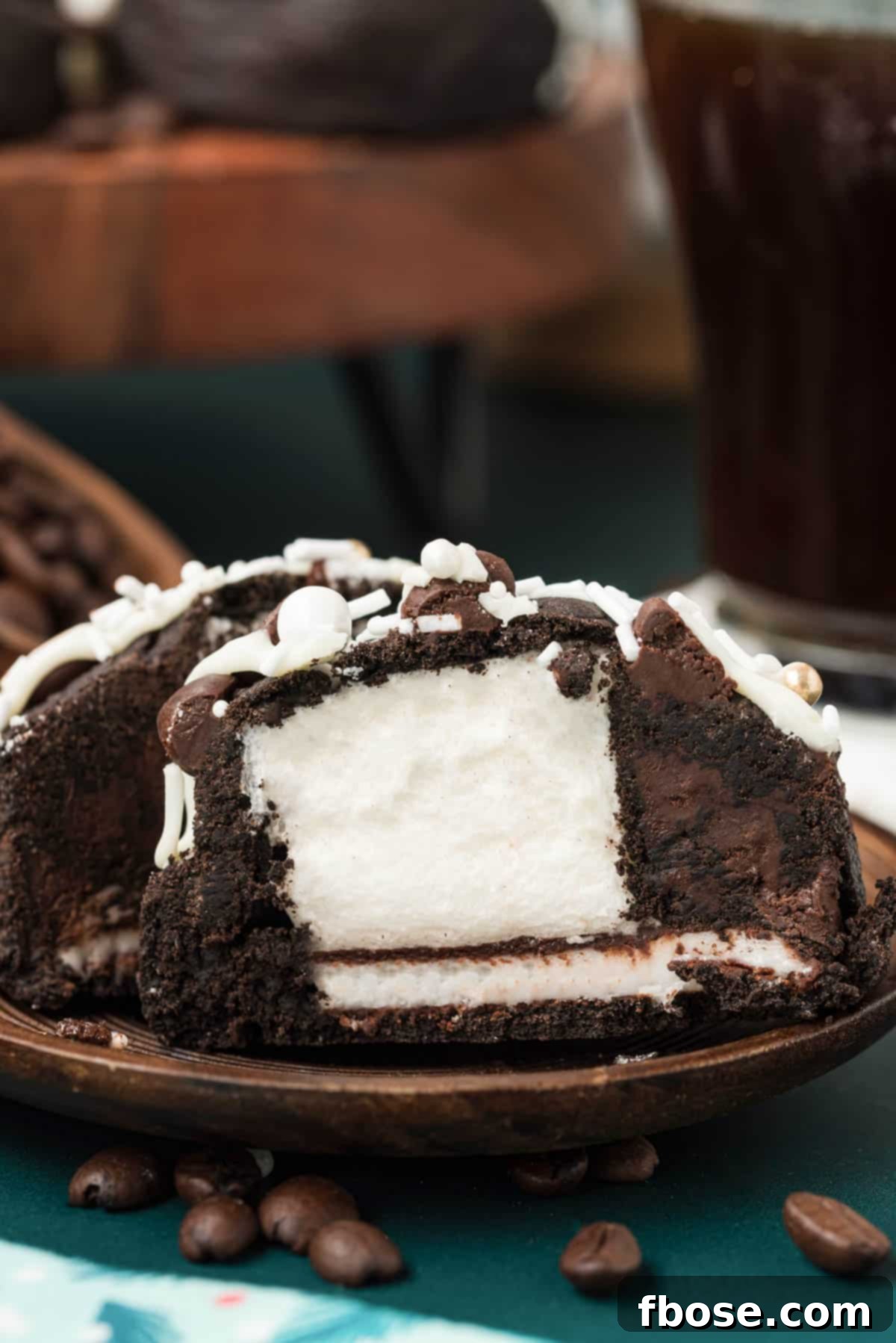 A Peppermint Mocha Cookie, sliced open to reveal its delightful marshmallow and peppermint patty stuffing, resting on a wooden board.
