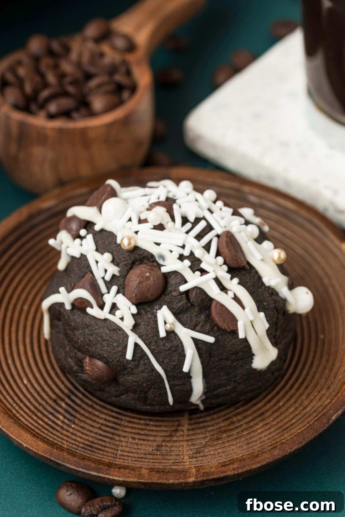 A gourmet Peppermint Mocha Cookie presented elegantly on a wooden plate, adorned with coffee beans for a rustic and aromatic touch.