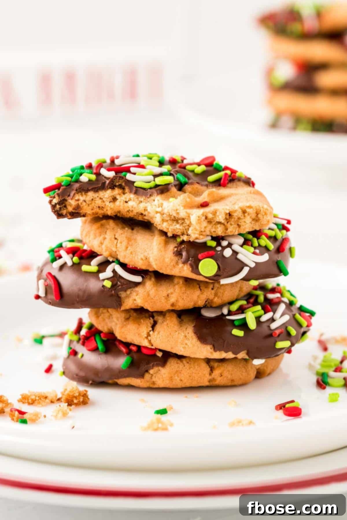 A stack of peanut butter Christmas cookies on a white plate.