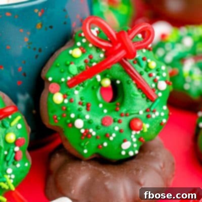 Simple Christmas Wreath Bites 7 Christmas wreath cookies leaning against a blue mug.