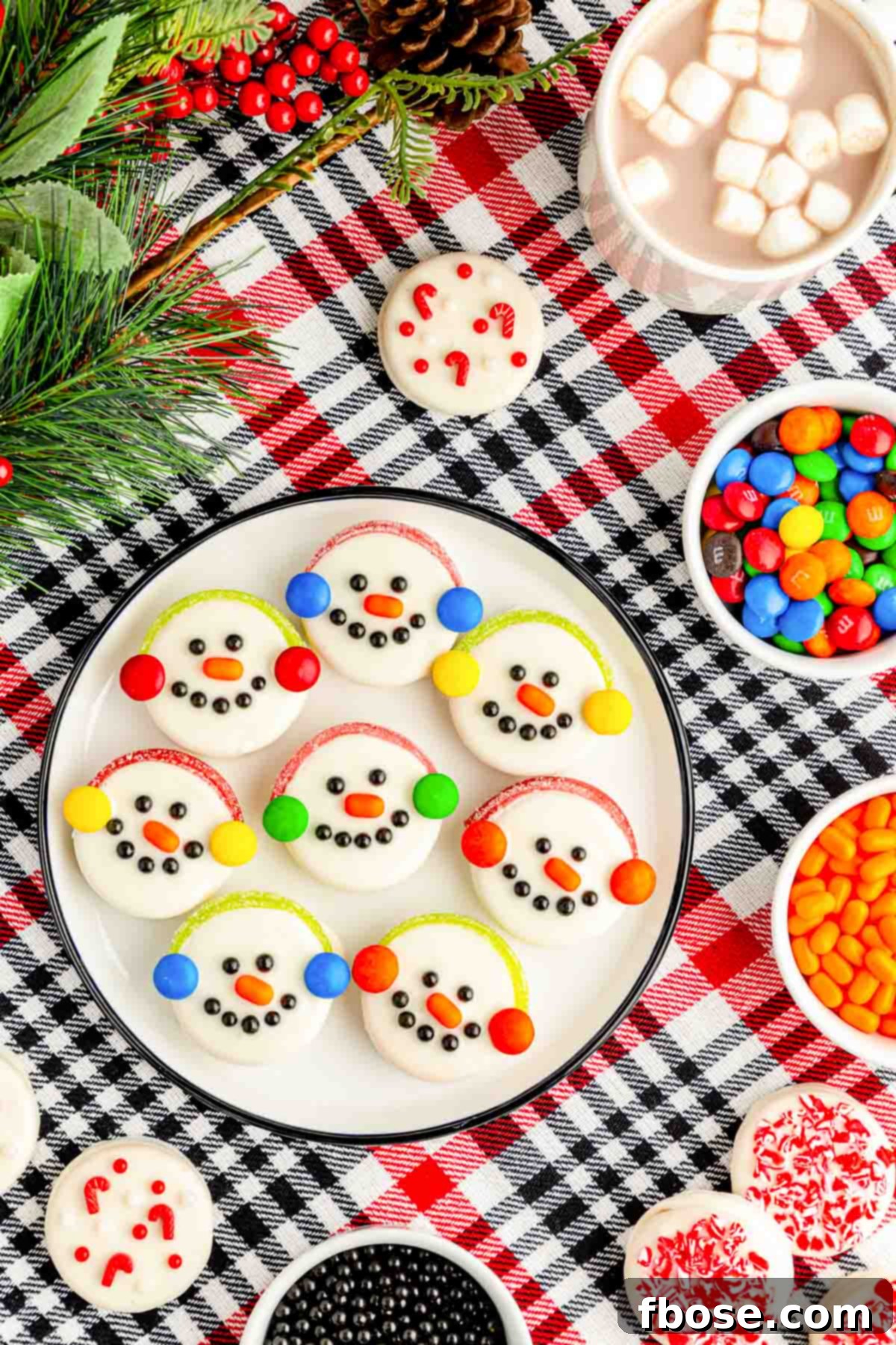 Overhead photo of white chocolate dipped Oreos decorated like snowmen.