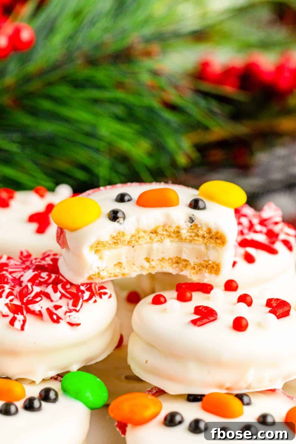 A white chocolate dipped Oreo decorated like a snowman with a bite missing.