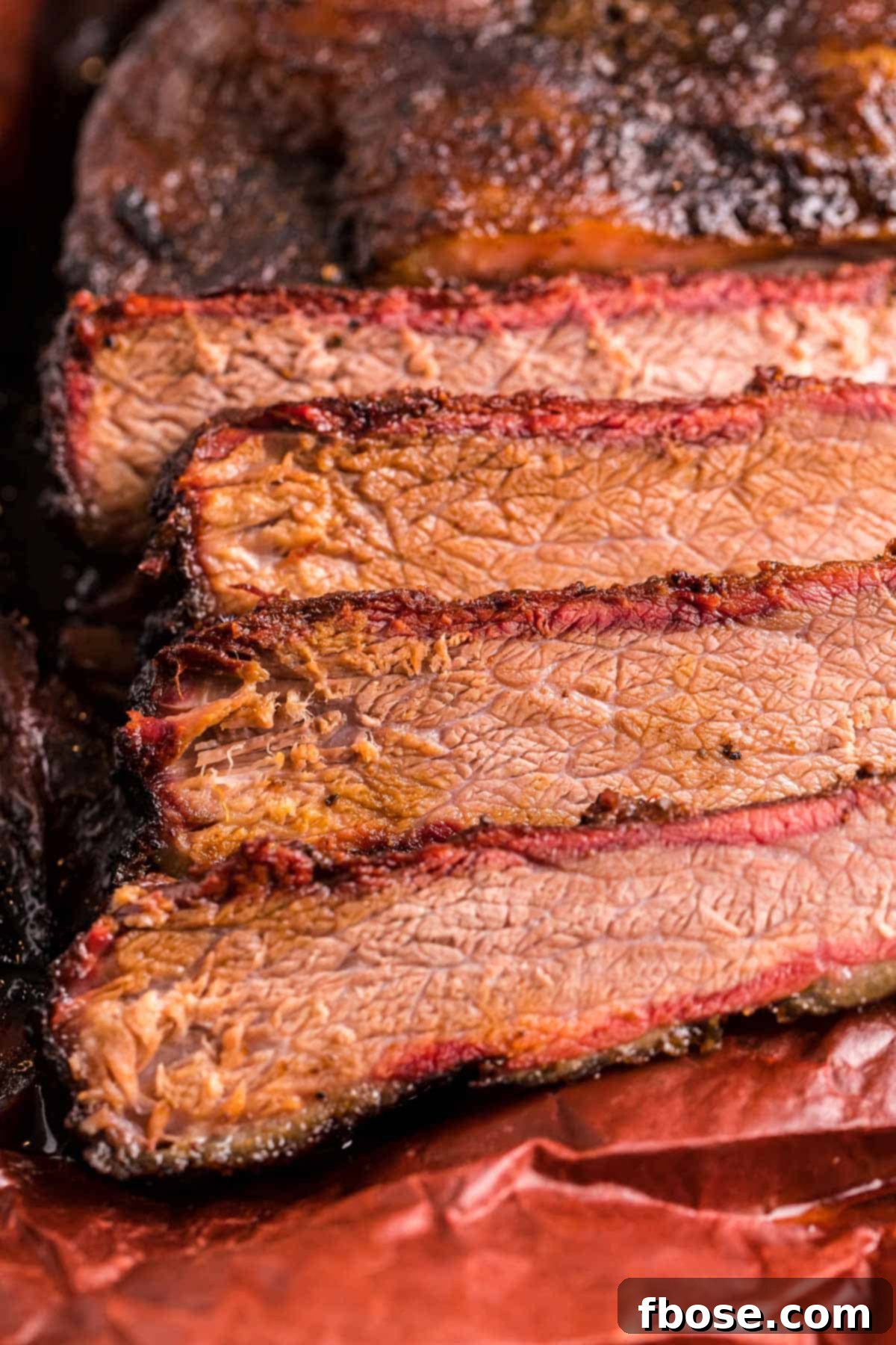 Slow-Smoked Brisket Perfection 3 Close-up of perfectly sliced smoked beef brisket, revealing its moist, tender interior and beautiful smoke ring.