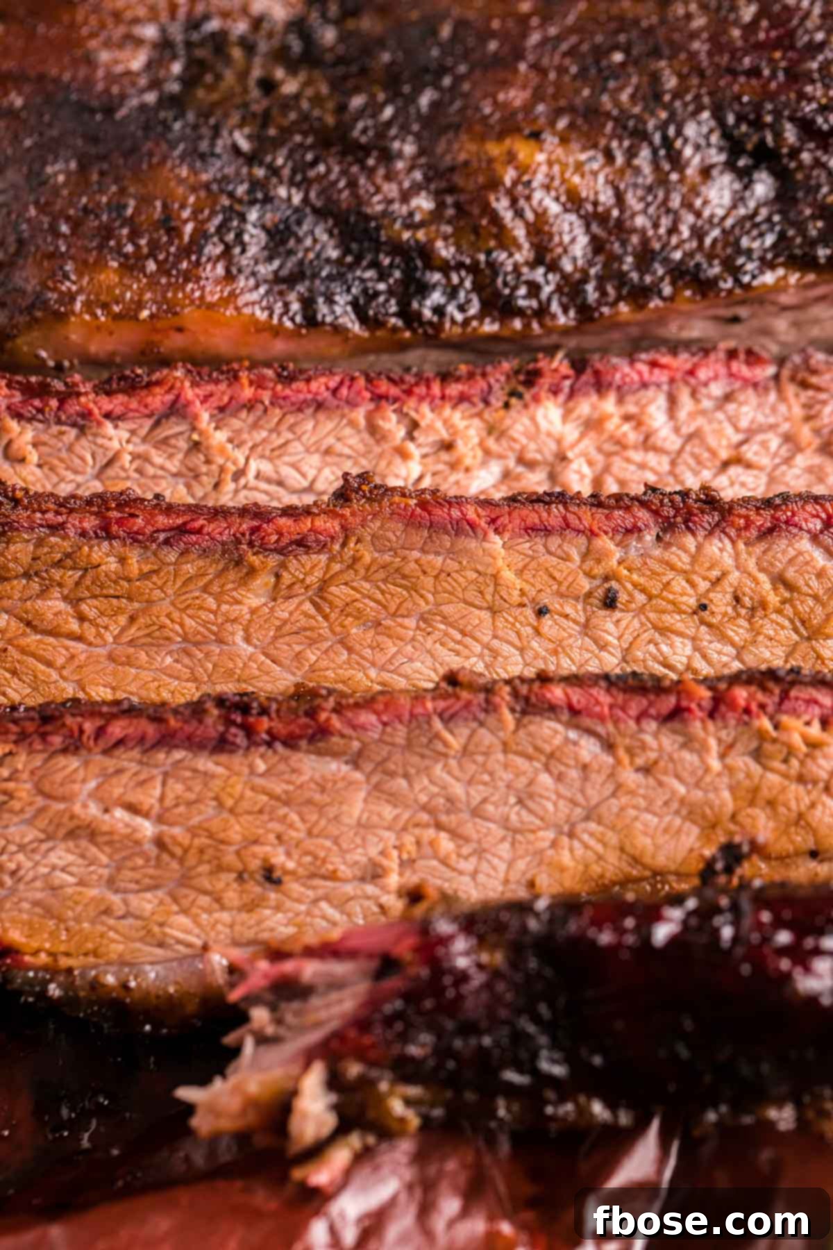 Slow-Smoked Brisket Perfection 6 Close-up photo of beautifully sliced smoked beef brisket, showcasing its tender texture.