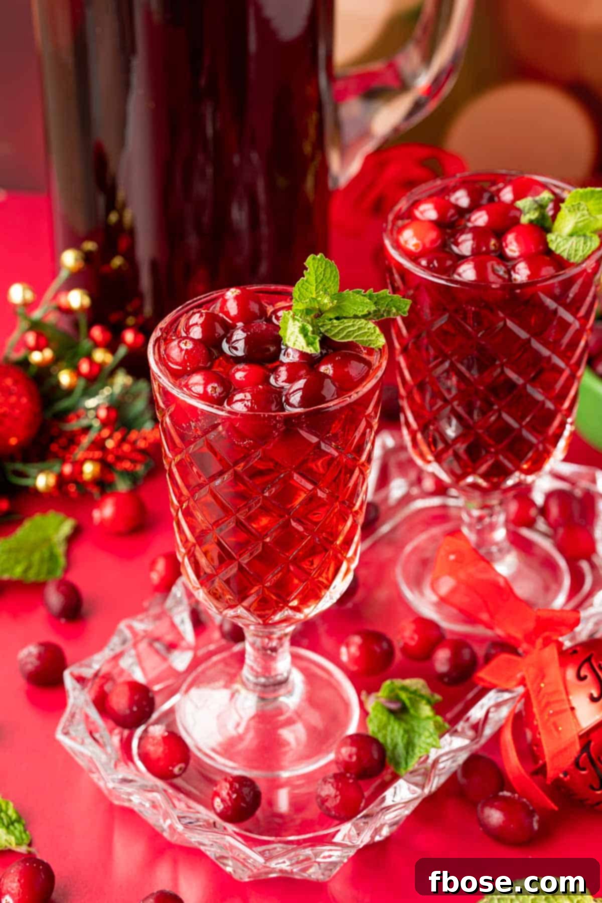 Two glasses of jingle juice on a glass tray with a pitcher behind them.