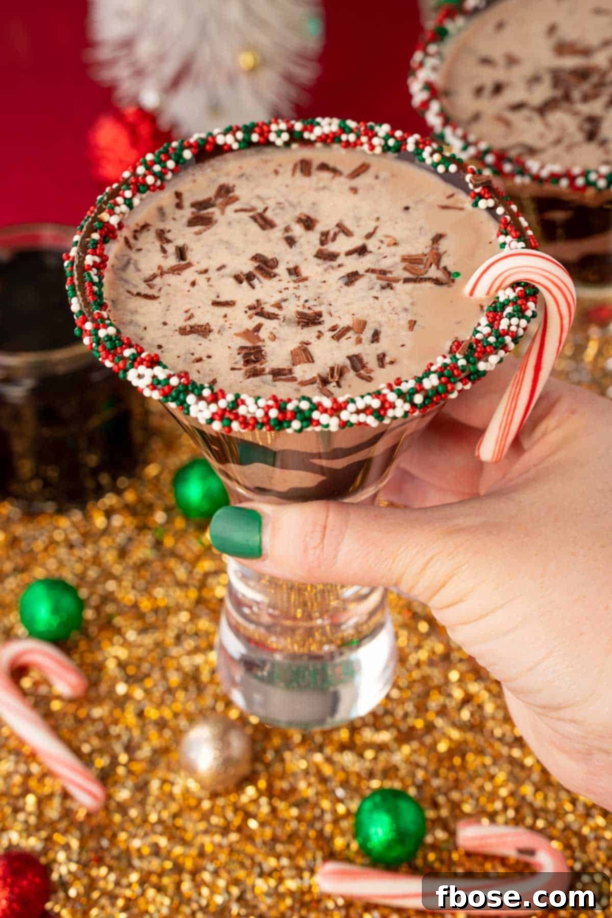 Peppermint Kiss Martini 5 A woman's hand holding a martini glass with a chocolate peppermint martini to the camera.
