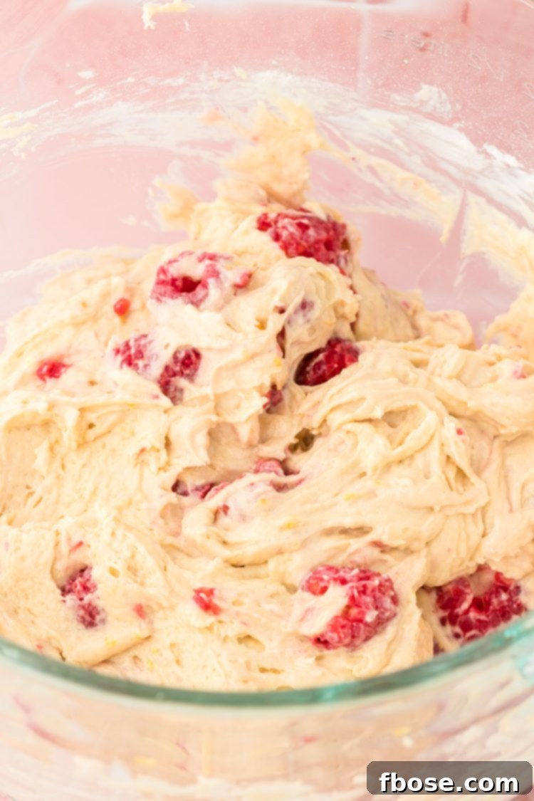 Fresh raspberries gently folded into the luscious cake batter with a rubber spatula, ensuring even distribution.
