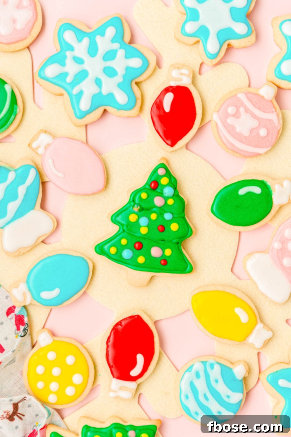 Overhead photo of iced christmas sugar cookies on a table.