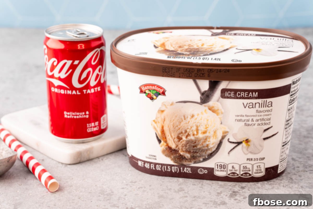 Ingredients to make a Coke float on a gray table.