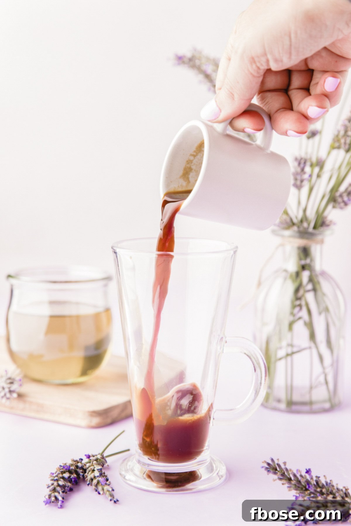 A stream of freshly brewed espresso gracefully pouring into a pristine white mug, setting the stage for a delightful lavender latte.
