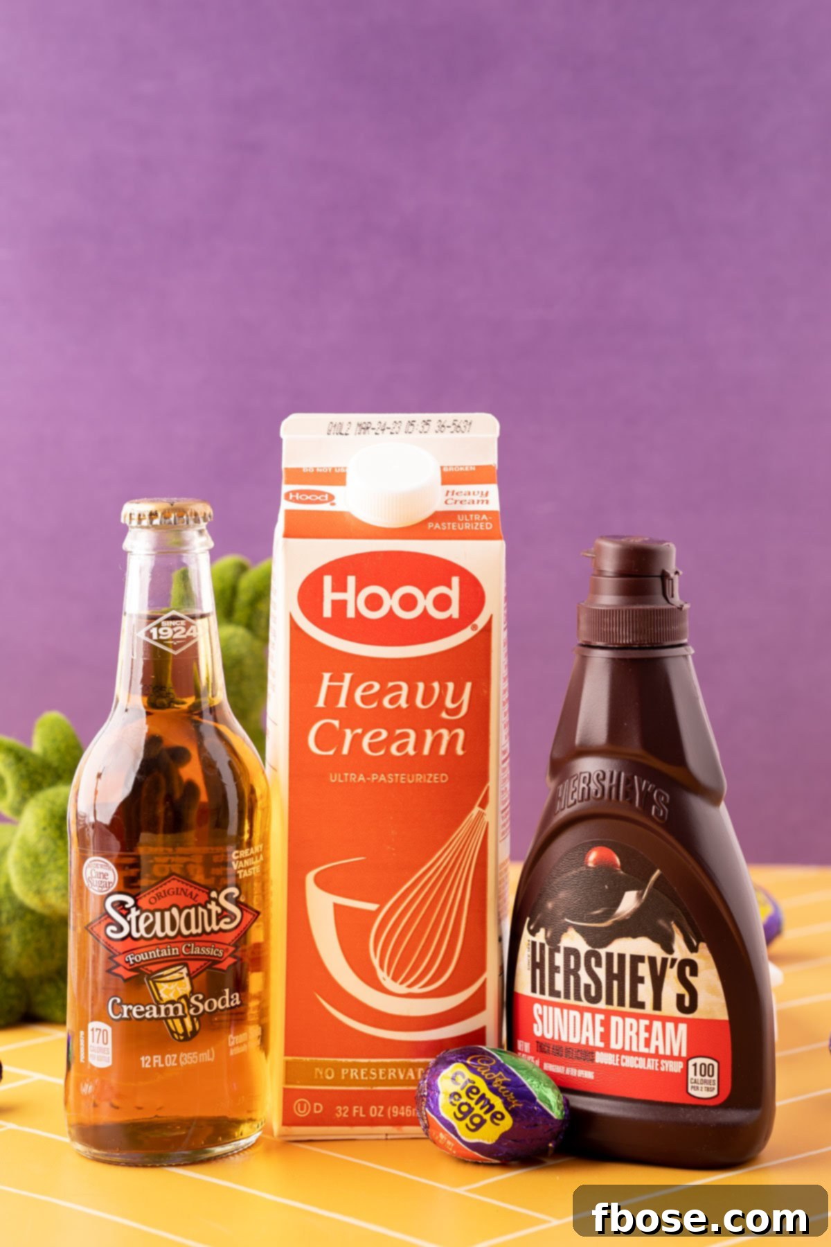 Ingredients to make Cadbury Creme Egg Dirty Soda on a yellow table.