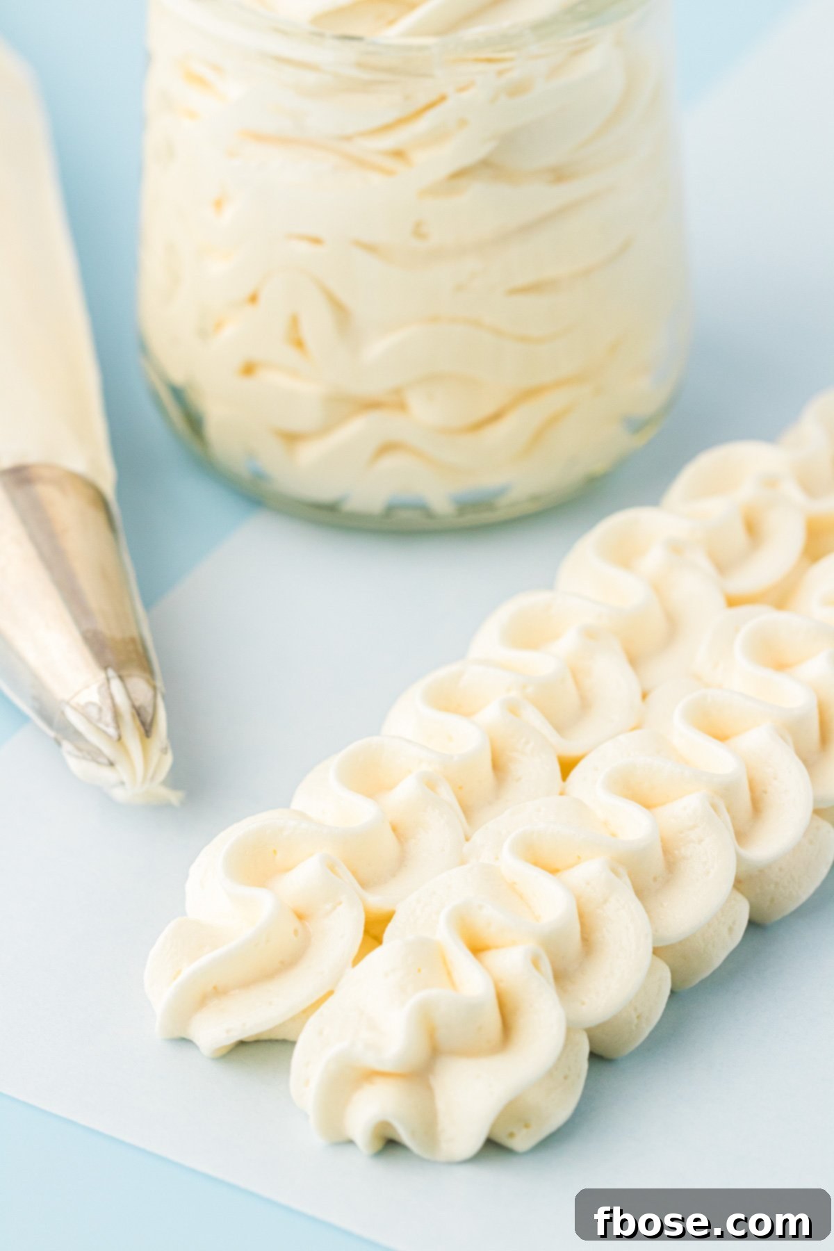 Vanilla American Buttercream Frosting piped onto a piece of parchment paper.