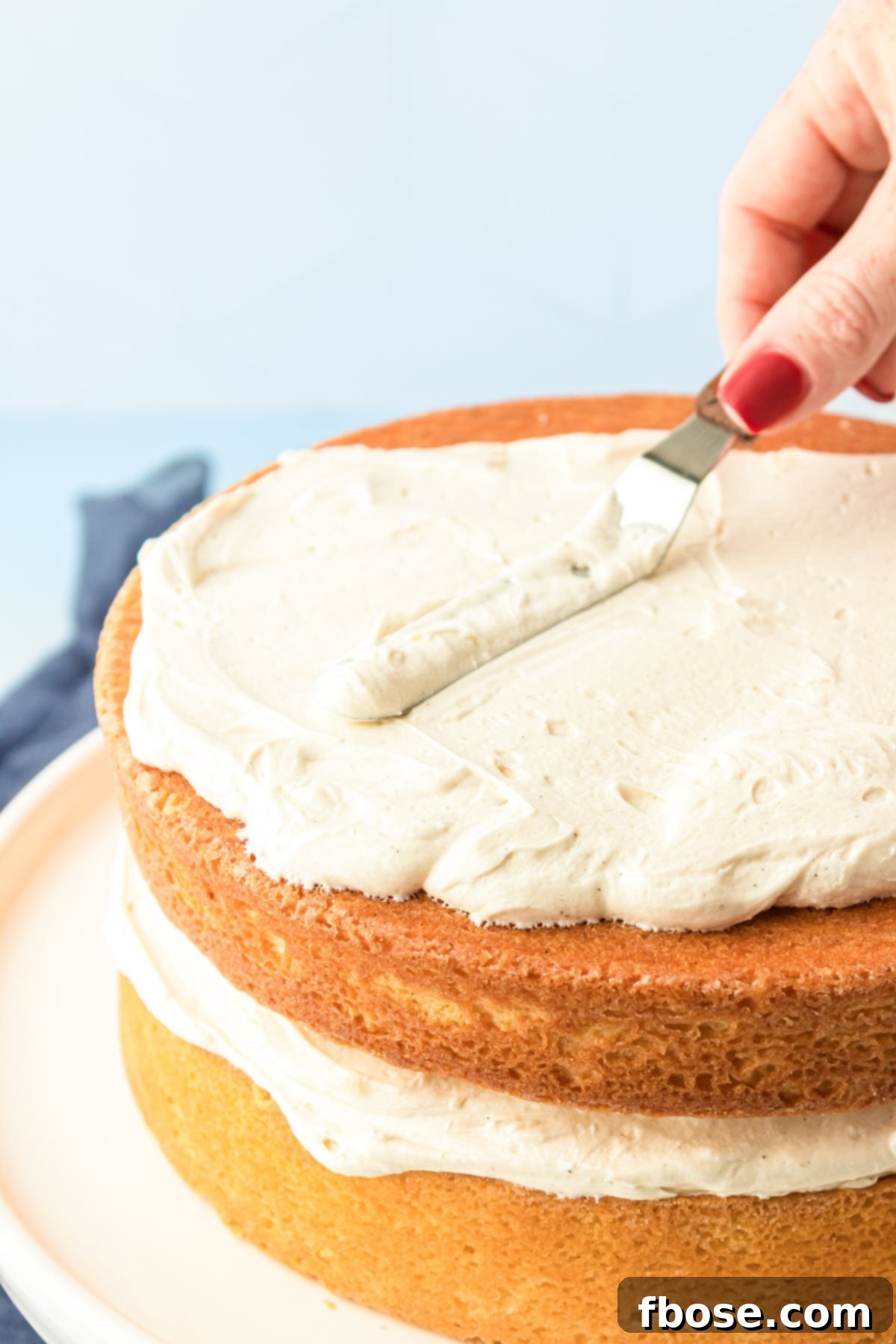 American Buttercream Frosting with vanilla bean being spread on a cake.