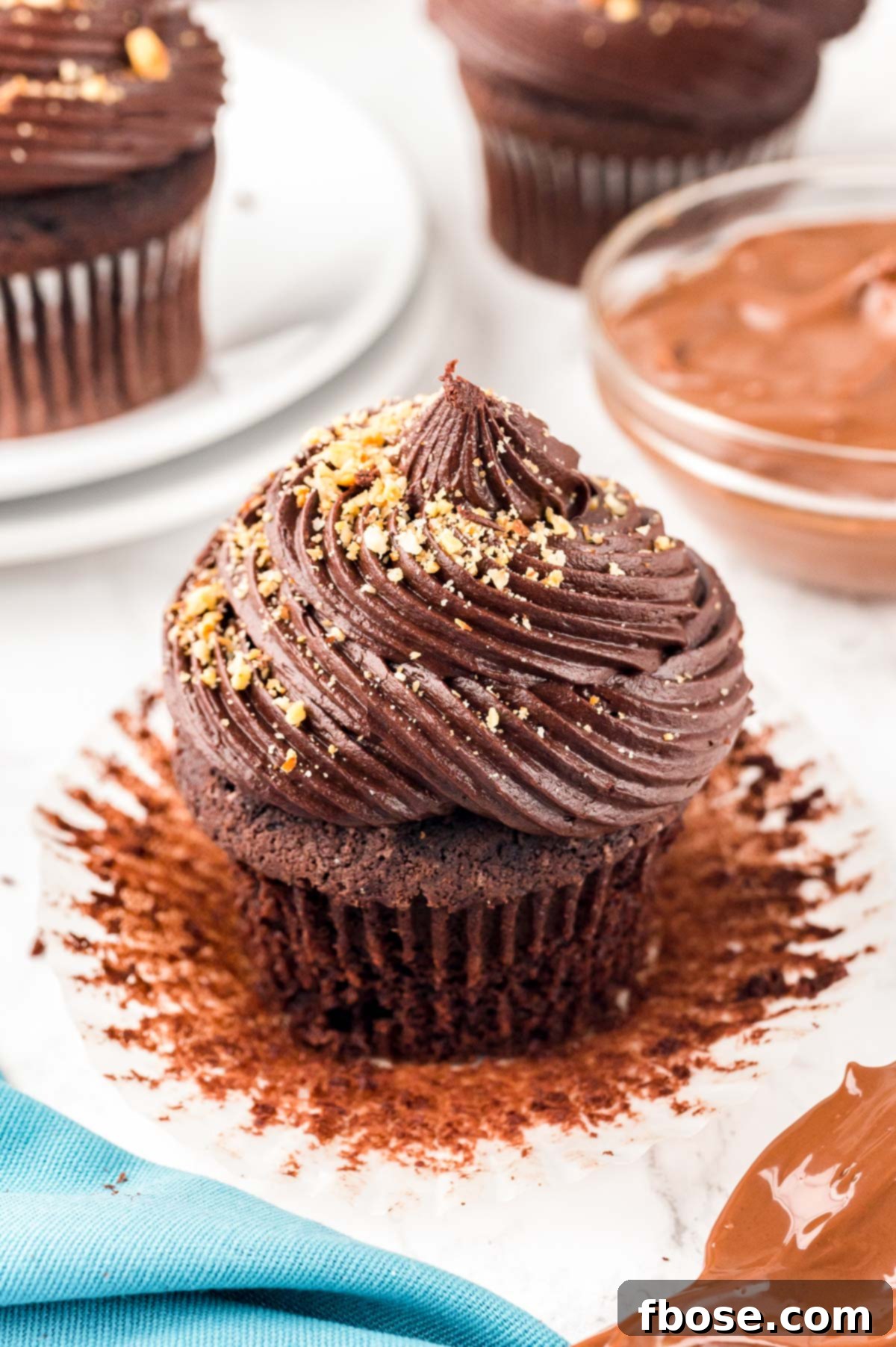 Decadent Nutella Cupcakes 9 Close up of a single, perfectly frosted chocolate hazelnut cupcake on a kitchen counter, ready to be enjoyed.
