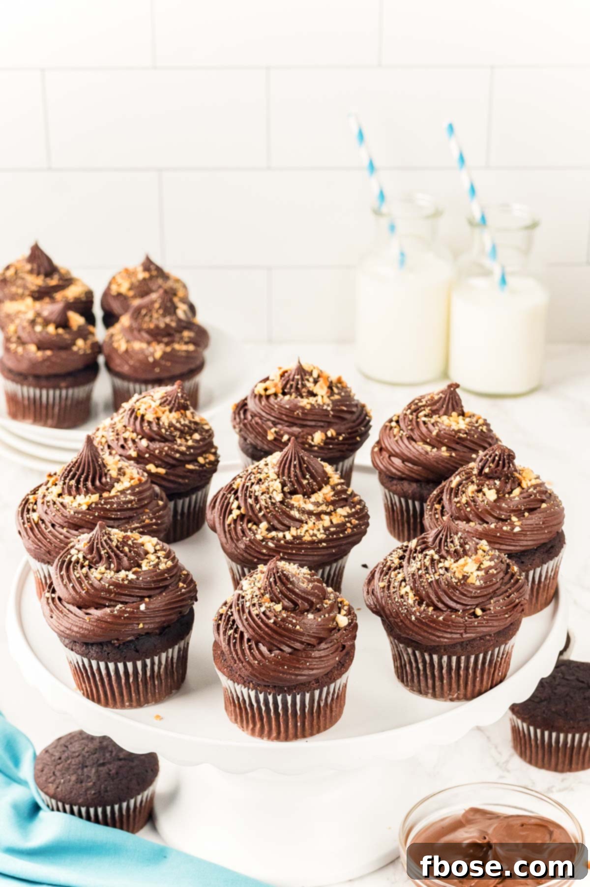 Decadent Nutella Cupcakes 7 Artistically arranged Nutella Cupcakes on a pristine white plate, showcasing their inviting frosting and hazelnut garnish.