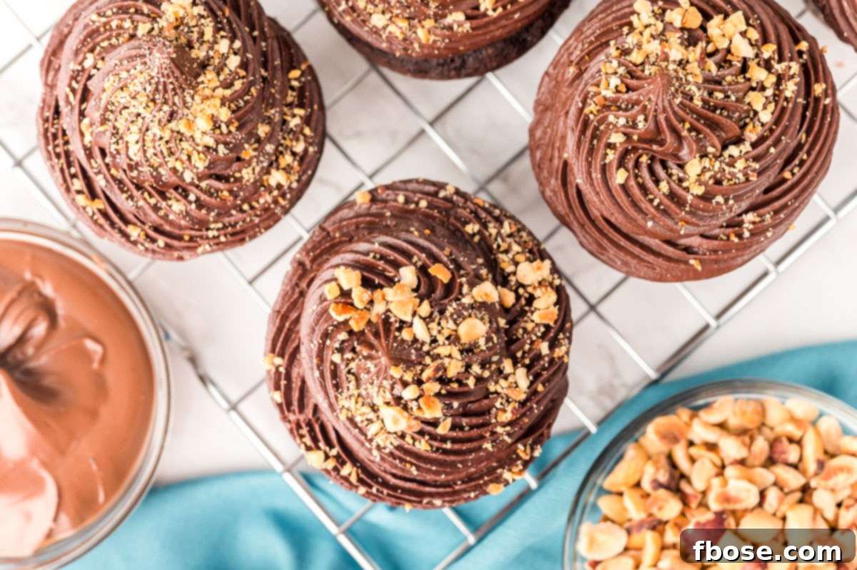 Decadent Nutella Cupcakes 8 An inviting overhead photo of freshly baked chocolate hazelnut Nutella cupcakes cooling on a wire rack.