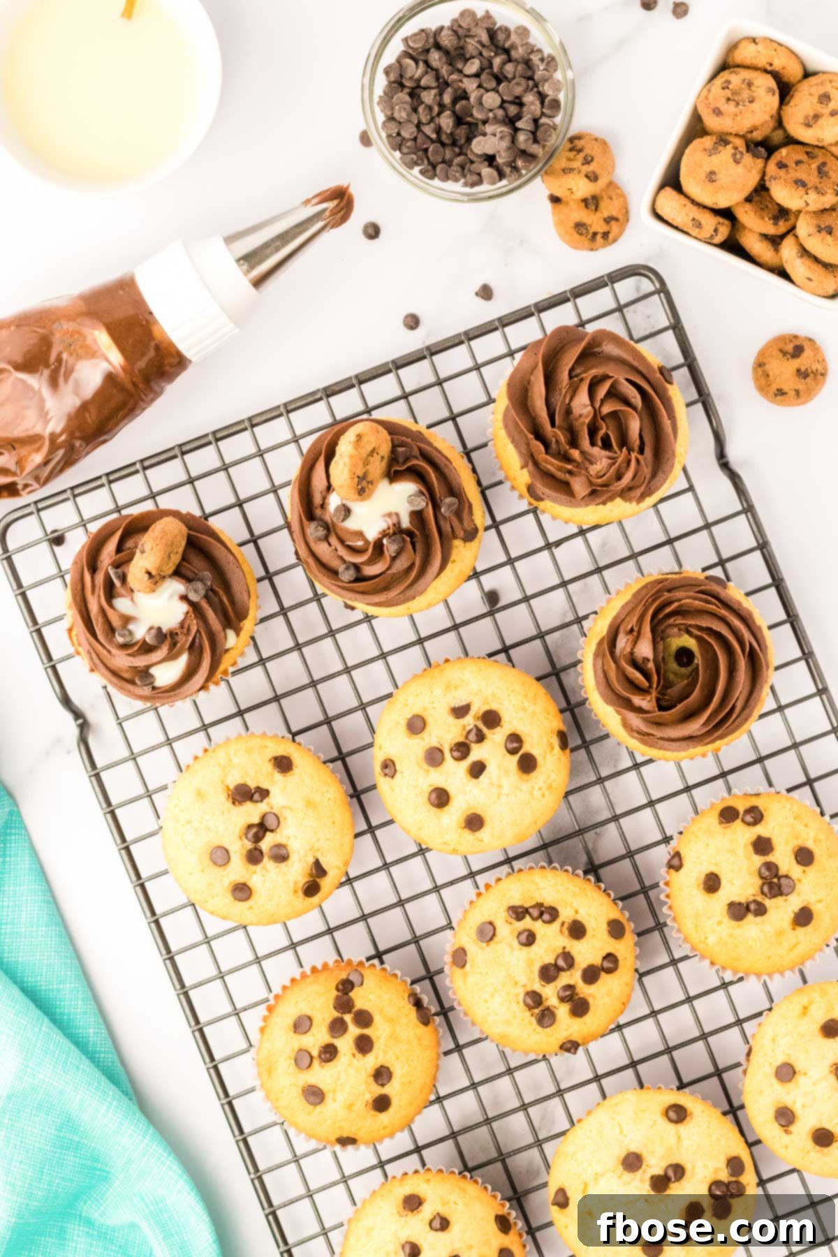 Chocolate frosting being piped onto chocolate chip cupcakes.