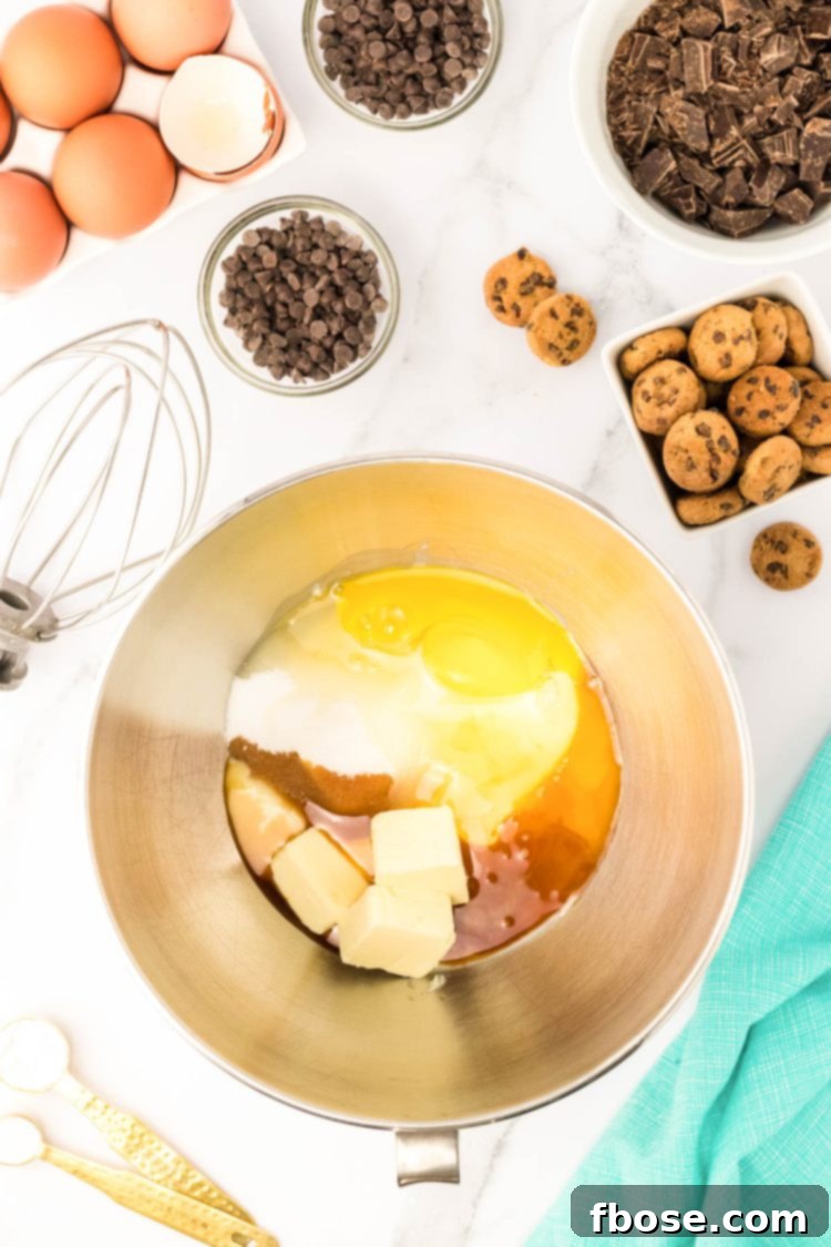 butter, sweetened condensed milk, vanilla, and eggs in a stand mixer ready to be mixed.
