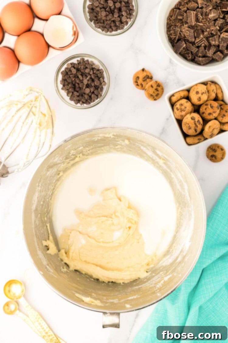 Milk being added to a bowl with cake batter.