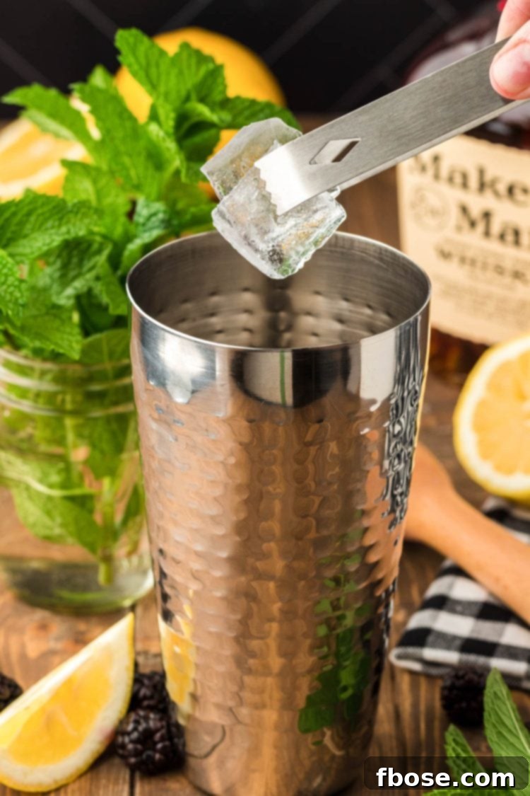 Ice being added to a cocktail shaker, ready for mixing.