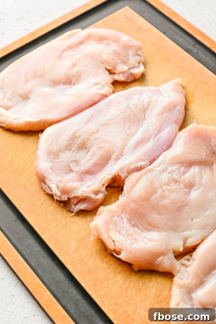 Chicken breasts pounded flat into thin cutlets, ready for breading.