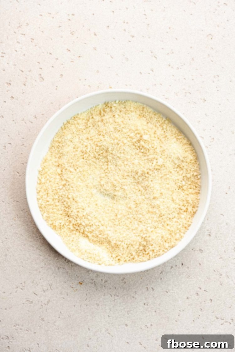 A bowl filled with a mixture of panko breadcrumbs and grated Parmesan cheese.