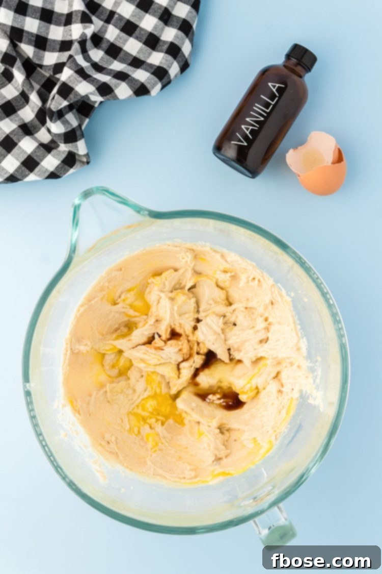 Eggs and vanilla being mixed into cookie dough.