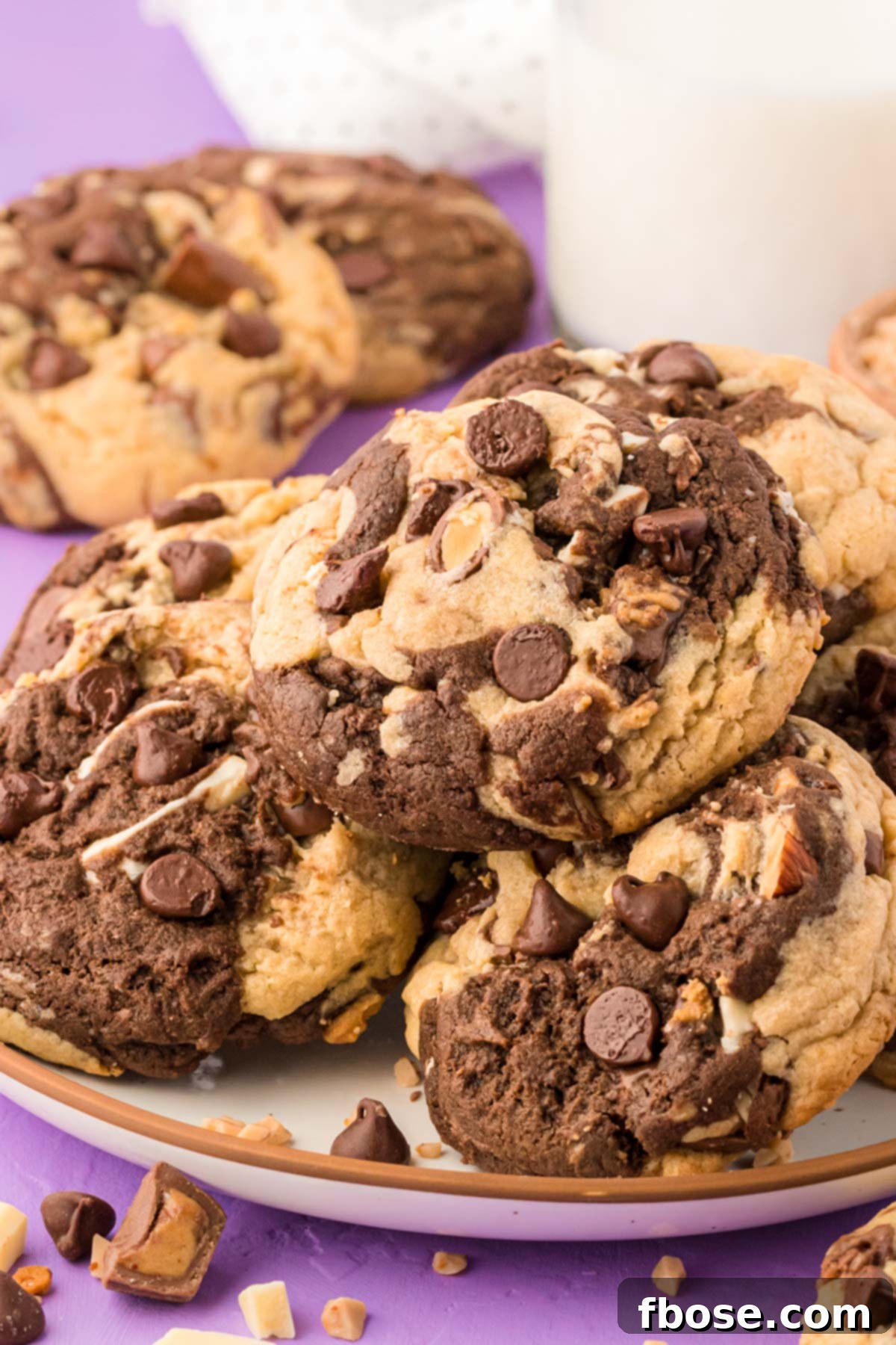 A selection of vanilla and chocolate Kitchen Sink Cookies artfully arranged on a white plate, ready to be served.
