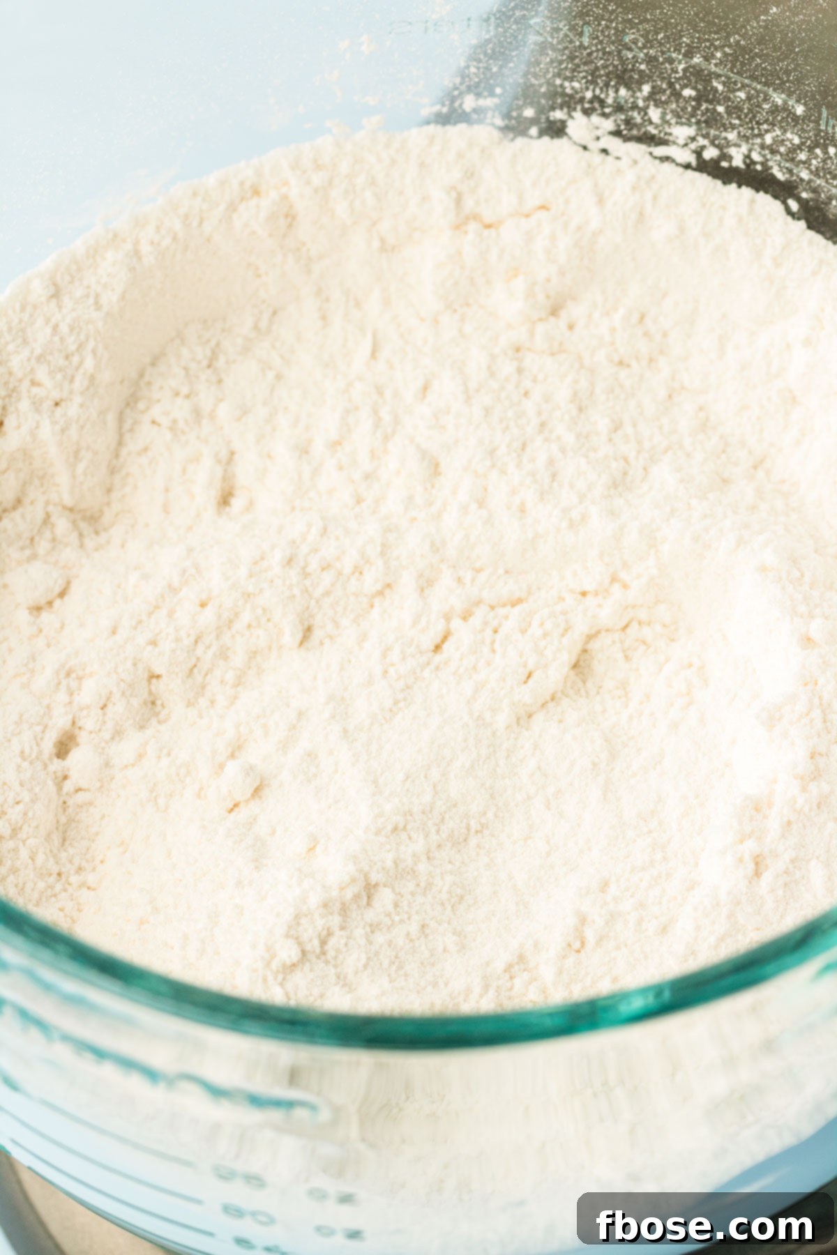 A close-up shot of dry ingredients for the cake, perfectly mixed together in a large stand mixer bowl, ready for the next step.
