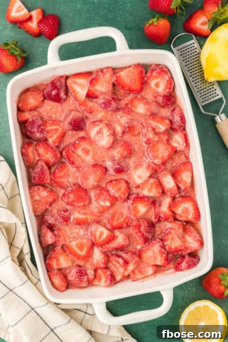Classic Strawberry Cobbler 11 An inviting overhead photo of a white baking dish filled with a vibrant strawberry mixture, ready for the oven.