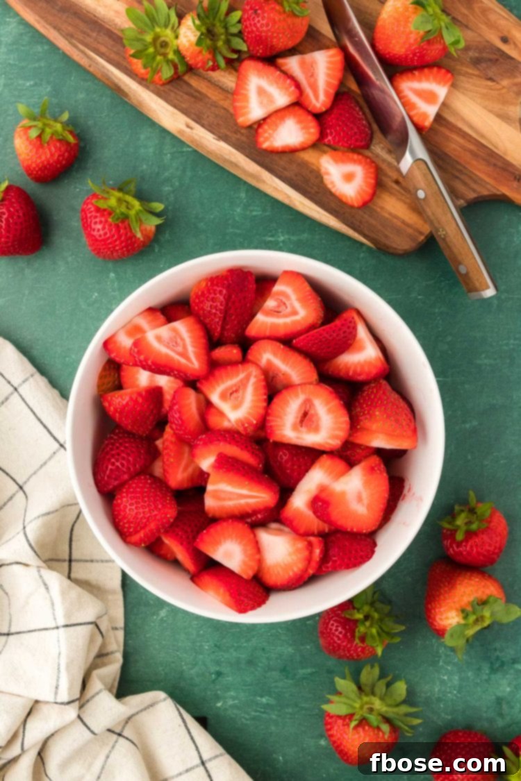 Classic Strawberry Cobbler 6 Fresh strawberries expertly prepped and sliced, nestled in a bowl, awaiting their transformation into a delicious cobbler.