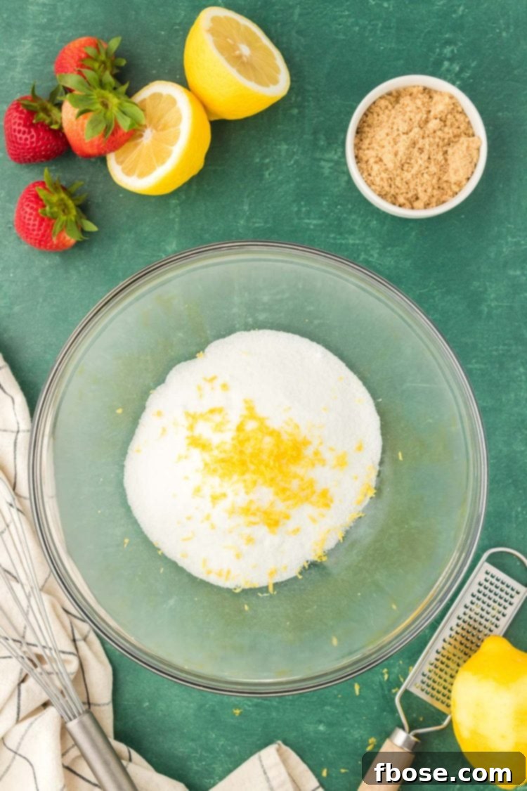 Classic Strawberry Cobbler 7 A bowl containing a vibrant mixture of lemon zest and various sugars, ready to be infused with flavor.