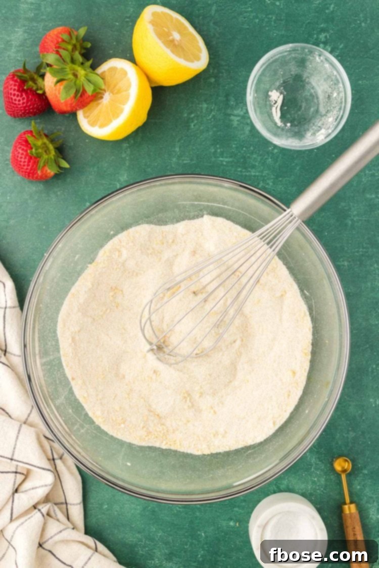 Classic Strawberry Cobbler 8 Baking ingredients, including flour and salt, being skillfully whisked together in a bowl.