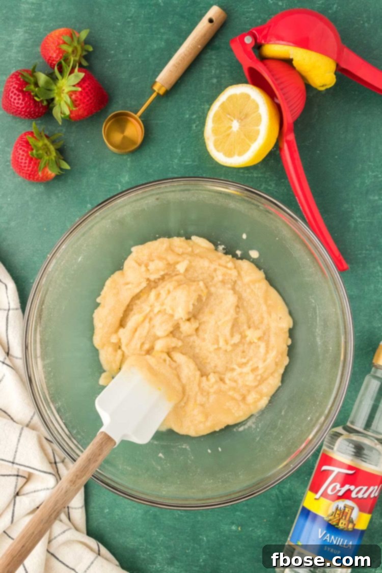 Classic Strawberry Cobbler 9 A vibrant mixture for the strawberry cobbler filling being thoroughly mixed in a bowl, ensuring all ingredients are well combined.