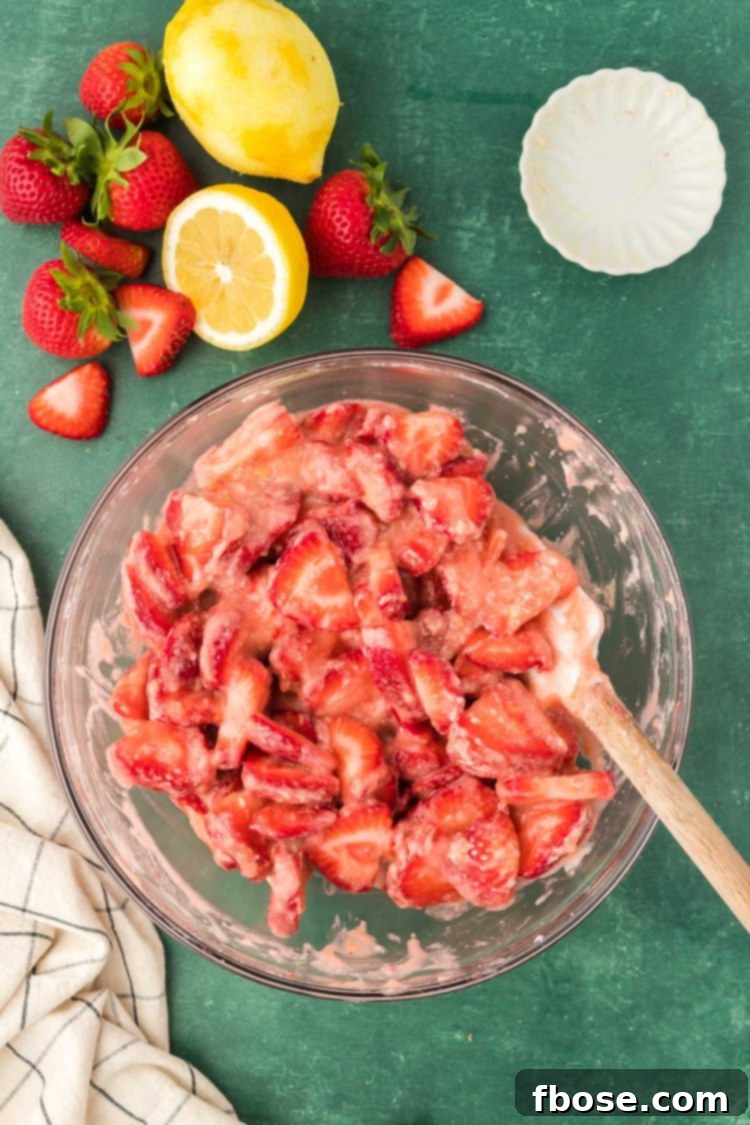 Classic Strawberry Cobbler 10 The delicious strawberry cobbler filling being mixed in a bowl, showcasing the rich, red berries and vibrant sauce.