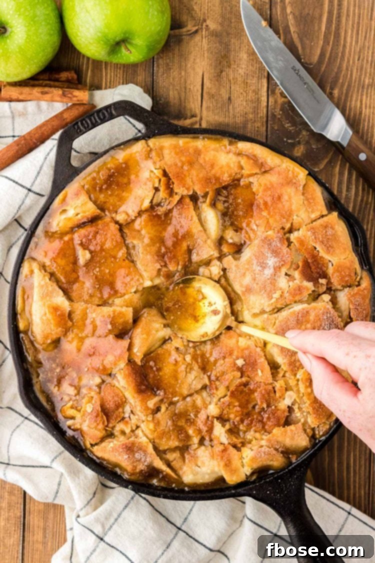 A spoon pressing pieces of cut pie crust into apple mixture.