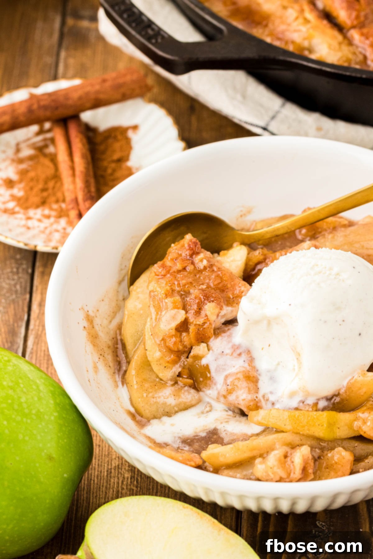 A white bowl with apple pan dowdy and ice cream in it.