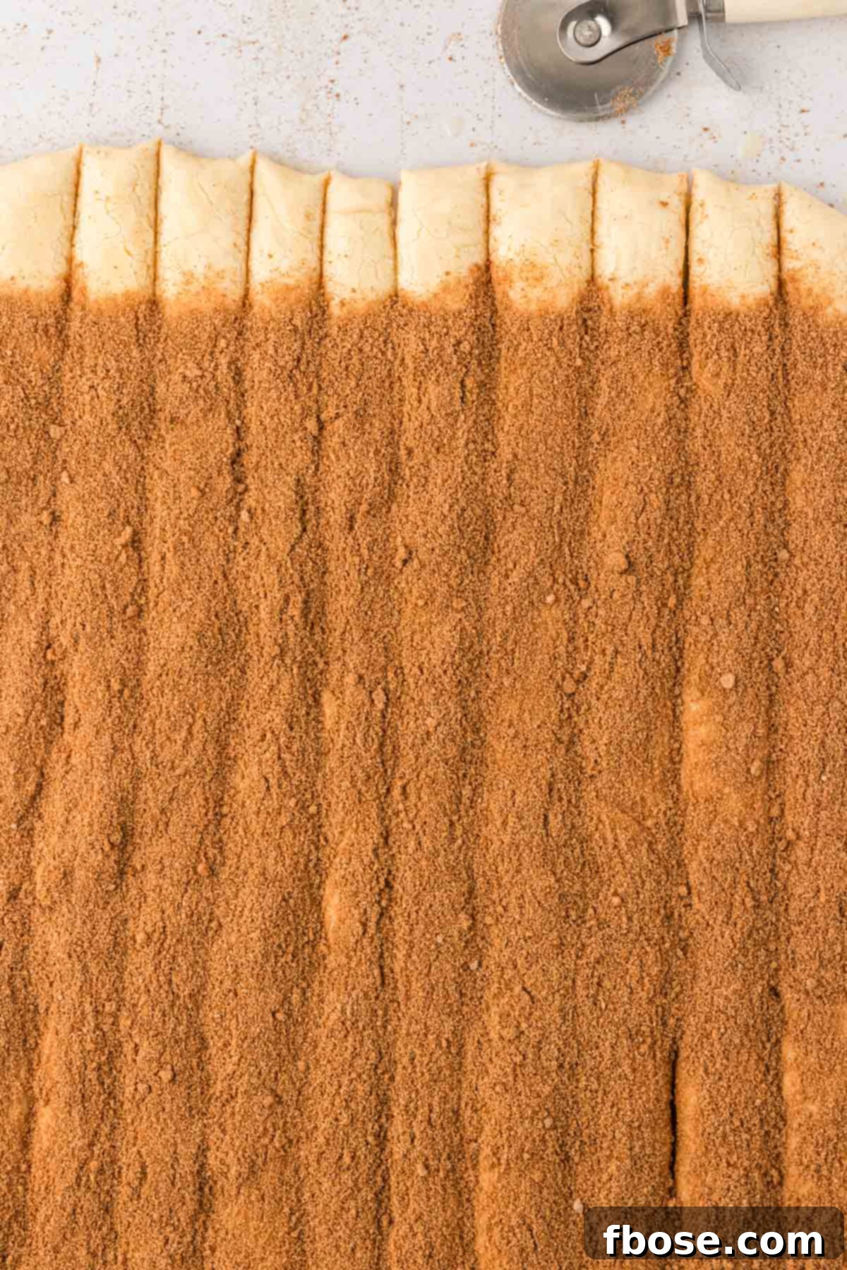 Cinnamon roll dough that's been sliced into strips.
