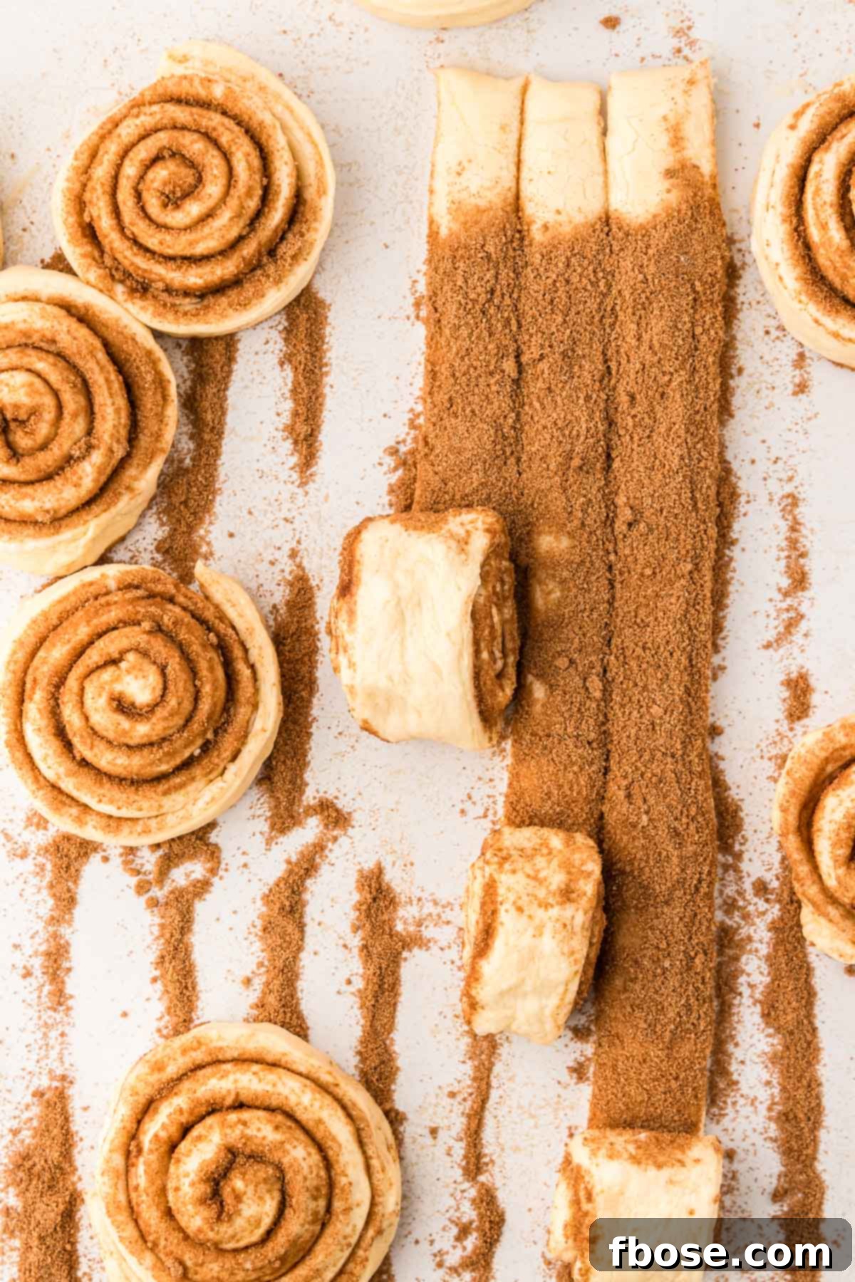 Cinnamon rolls being rolled up.