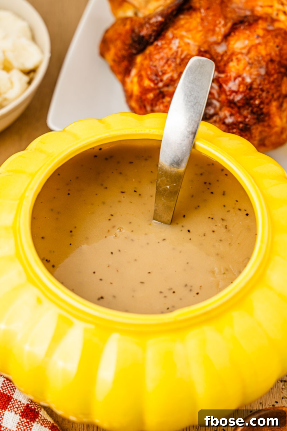 A yellow gravy boat filled with gravy.