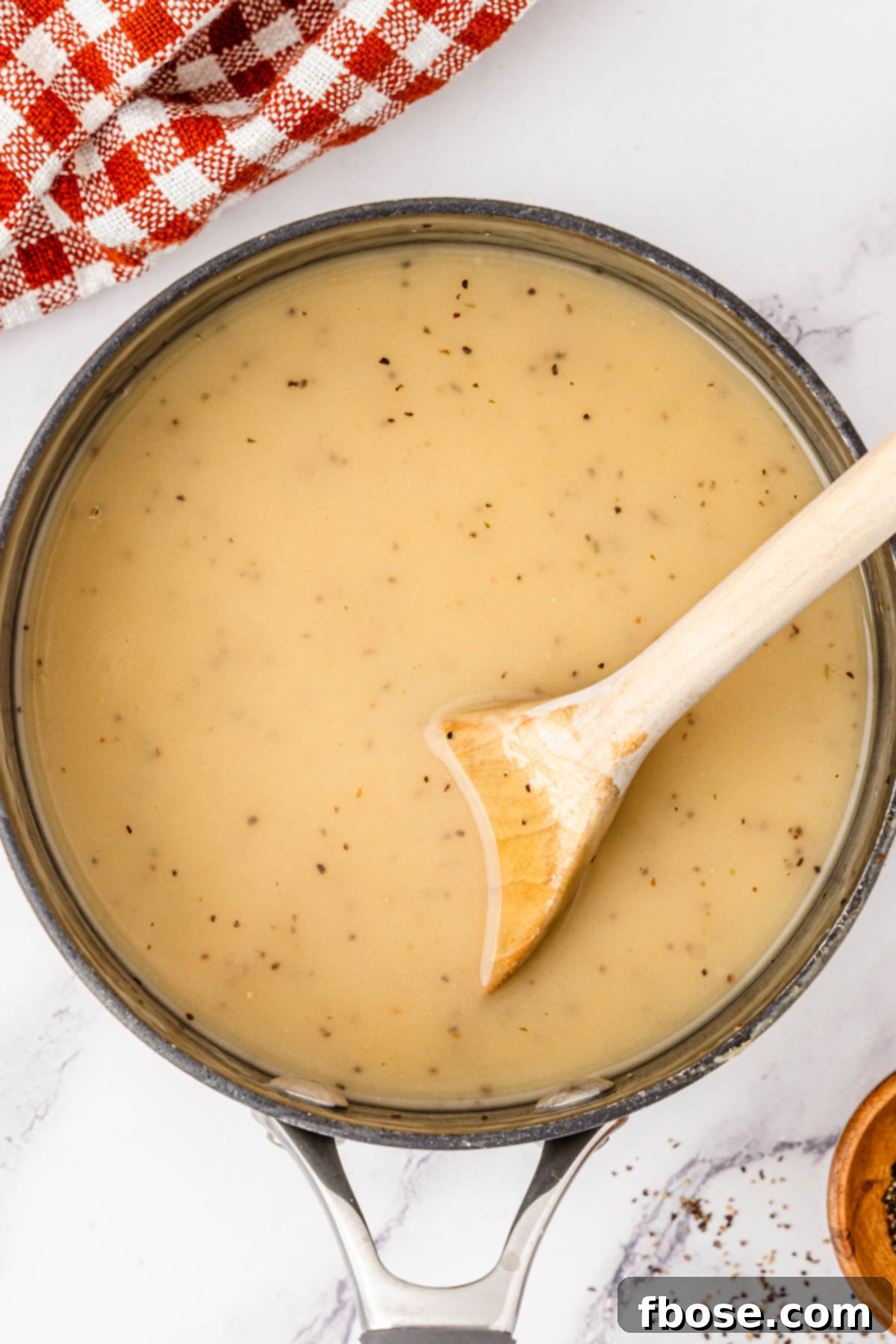 Turkey dripping gravy in a saucepan.