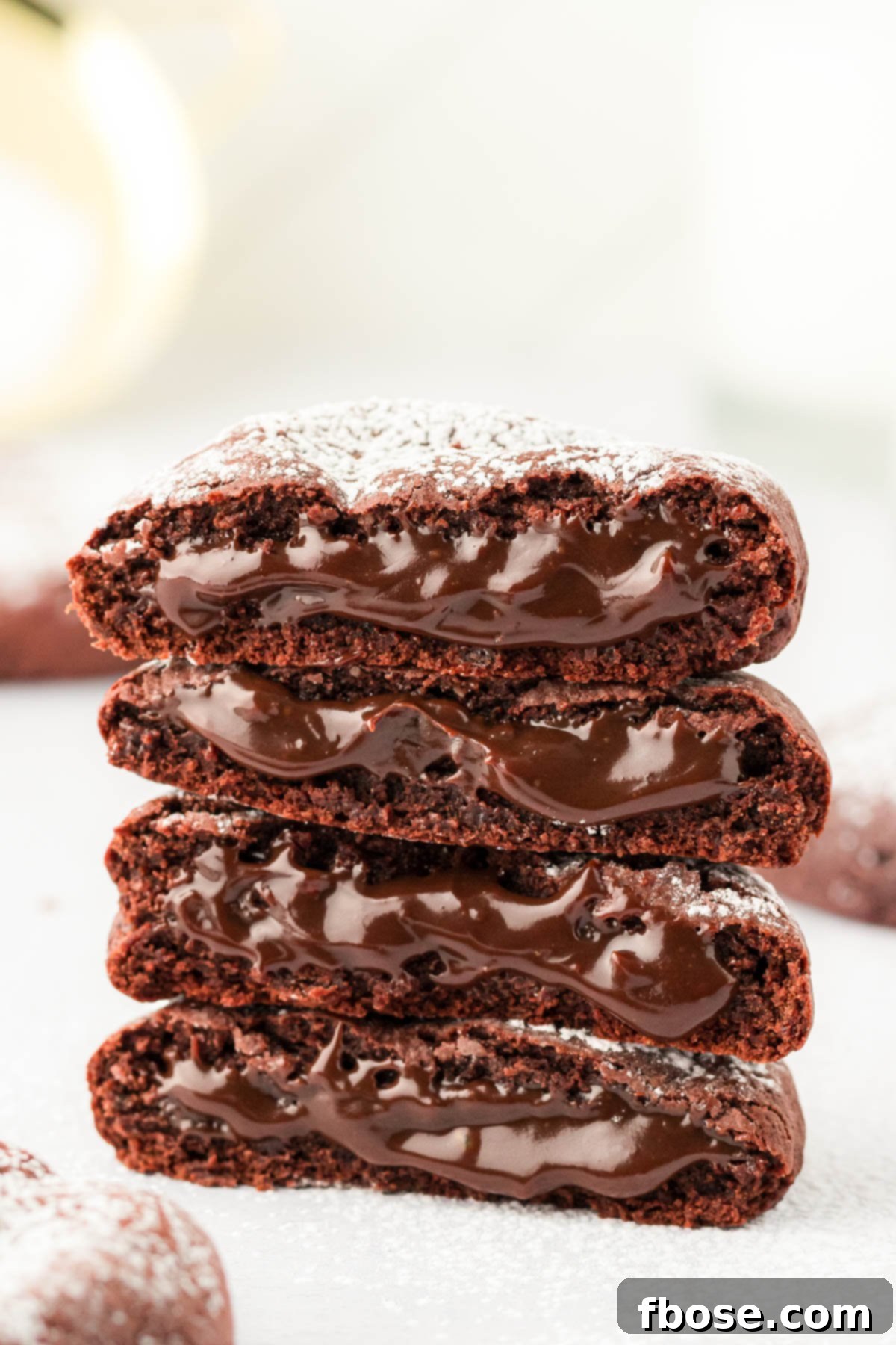 A stack of molten lava cake cookies on a white surface. 