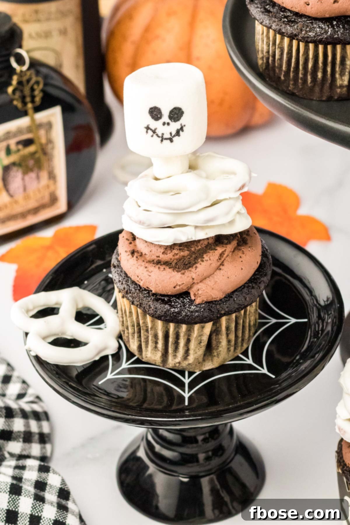 Spooky Skeleton Cupcakes 9 A chocolate skeleton cupcake on a black cake stand.