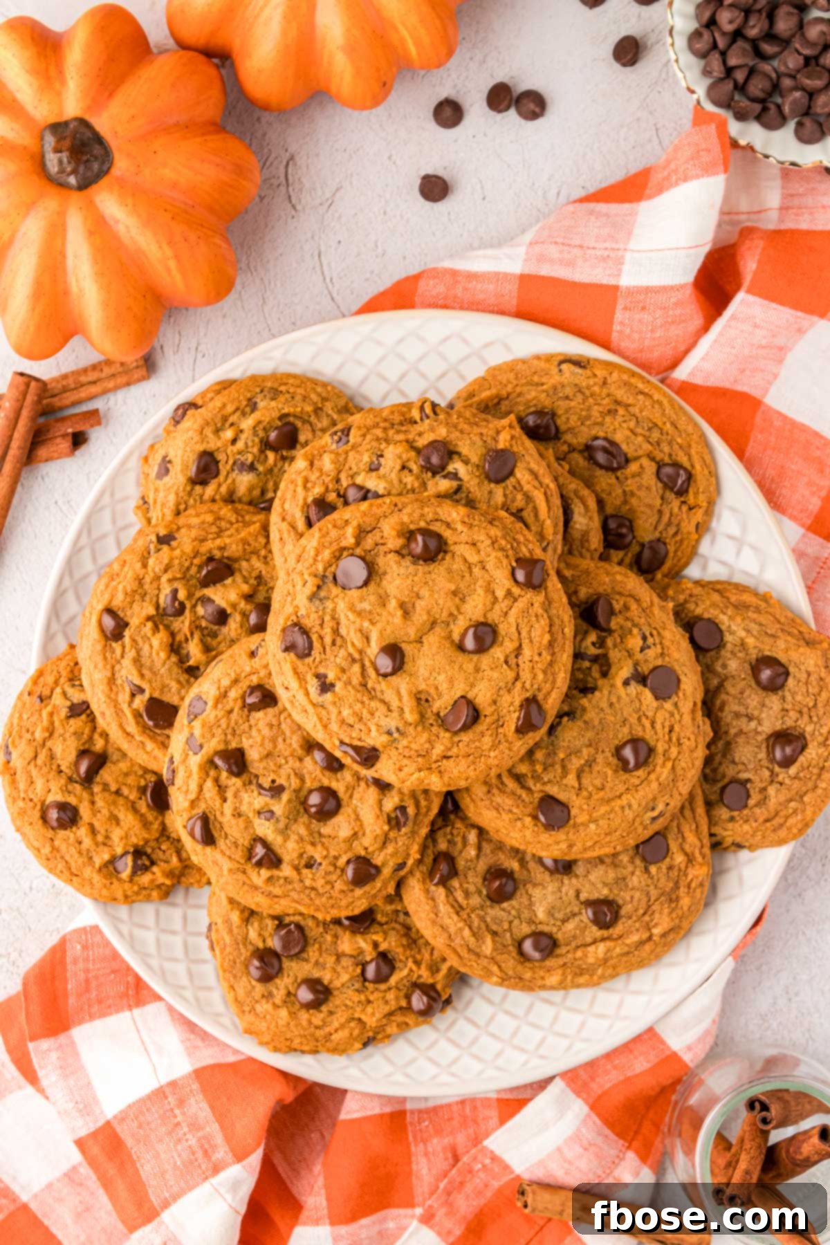 Velvety Pumpkin Chocolate Chip Delights 8 An overhead photo of a plate filled with freshly baked pumpkin chocolate chip cookies.